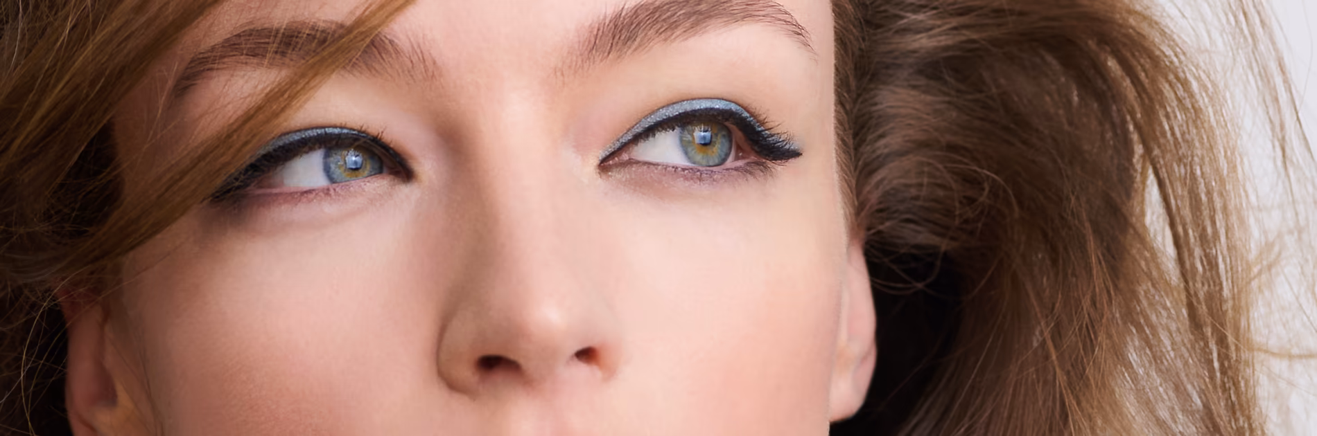 Nahaufnahme der Augen einer Frau mit präzisem, schimmerndem Eyeliner, passend zum Make-Up Trend Awakened für einen wachen und strahlenden Blick.